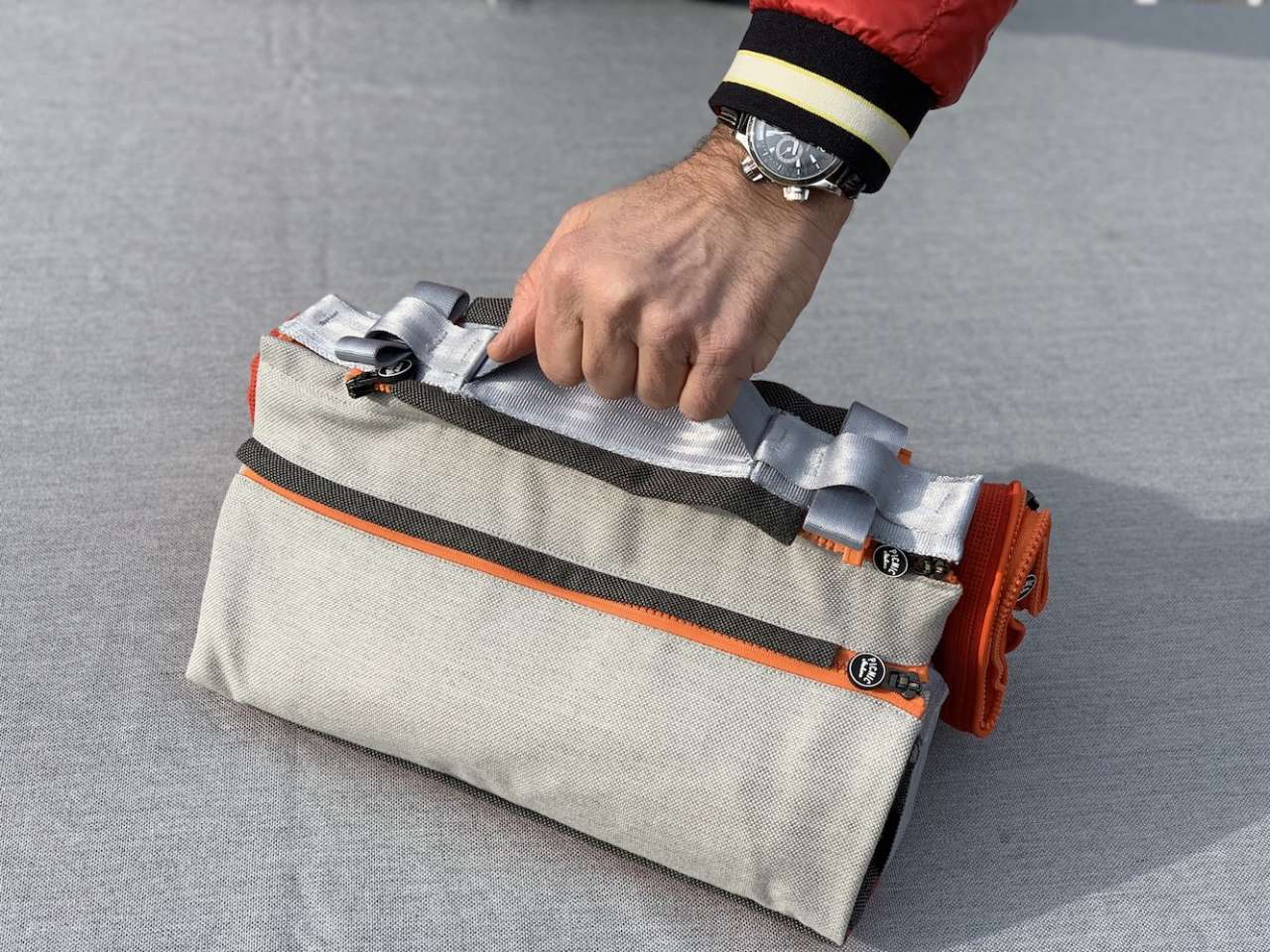 Eine Hand hält eine suba.coldbottle.pocket.silvergrey an einem Griff