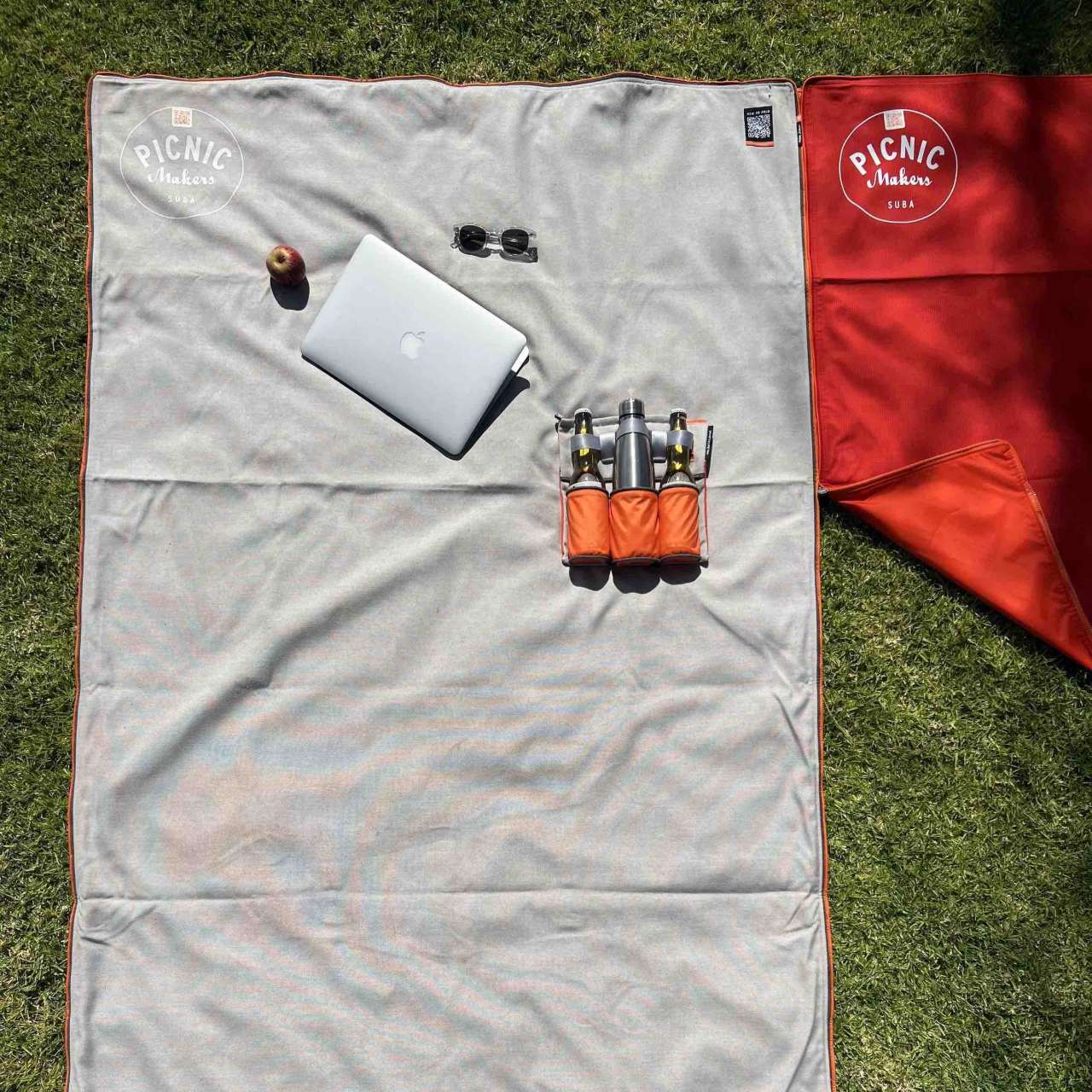 Top view on grass: suba.centralpark.33.silvergrey and suba.squarepark.33.red zipped together — different formats, one seamless surface