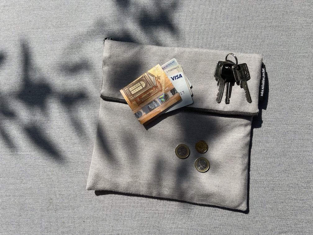 suba.valuables.pocket.silvergrey mit Geldscheinen, Münzgeld und Schlüsseln drauf