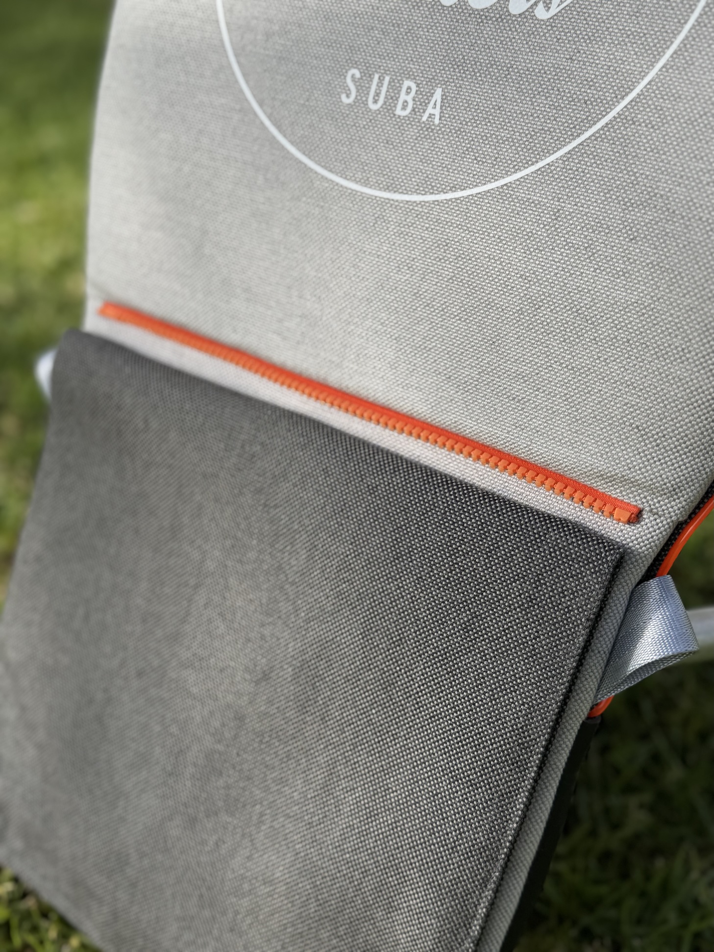 suba.backrest.silvergrey orange zipper detail from suba.zipSystem close-up on grass sunlit outdoor setting ☀️🌿
